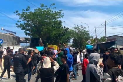 Massa aksi unjuk rasa berkumpul di depan PT Garam, Dusun Selabayan, Desa Sejati, Kecamatan Camplong, saat arus lalu lintas dan aktivitas warga di sekitar lokasi terdampak.
